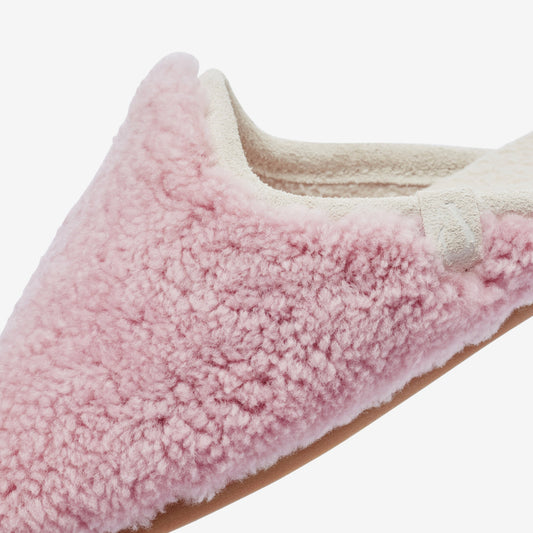 Dusty pink fuzzy mule slipper with cream fleece lining and brown sole, shown from side angle.