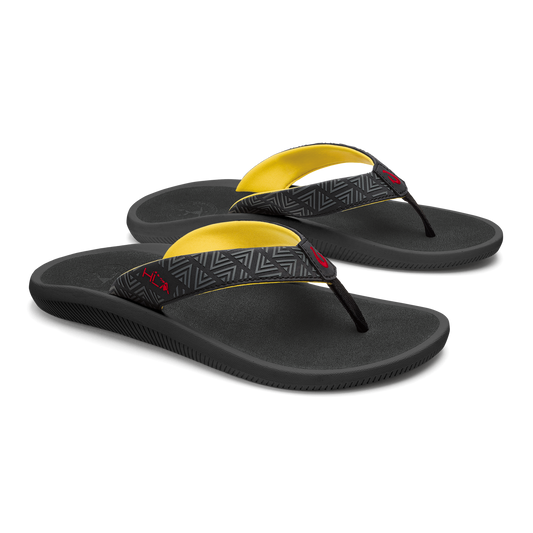 Black flip-flops with yellow arch straps and geometric patterned toe post bands.