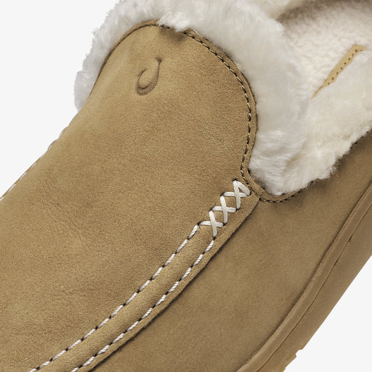 Tan suede slipper with white fleece lining and white cross-stitch detail along the side seam.