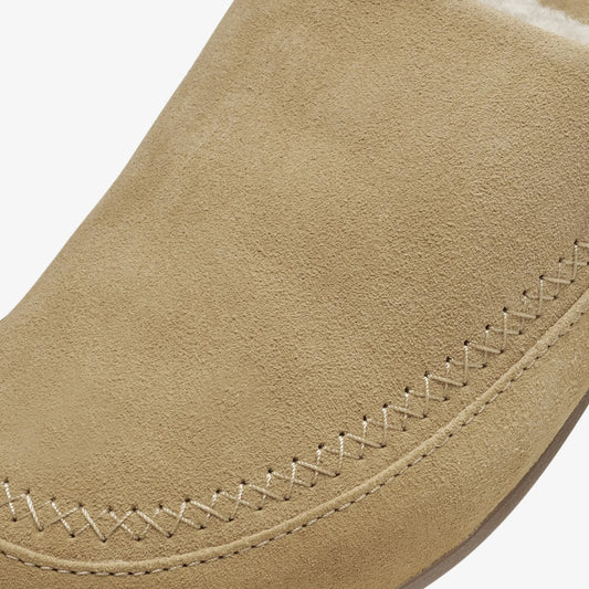 Tan suede shoe detail showing stitched seam along the edge.