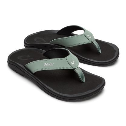 Pair of seagreen and black thong sandals with cushioned soles and decorative toe posts.