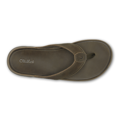 Brown Olukai thong sandal with woven strap and circular toe post detail, viewed from above.