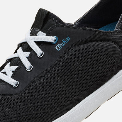 Black lace-up sneaker with white shoelaces, blue coral accents, and textured knit upper panel.