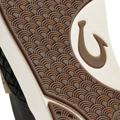 Brown and cream leather sandal with scalloped pattern design and hook closure detail, black sole visible.