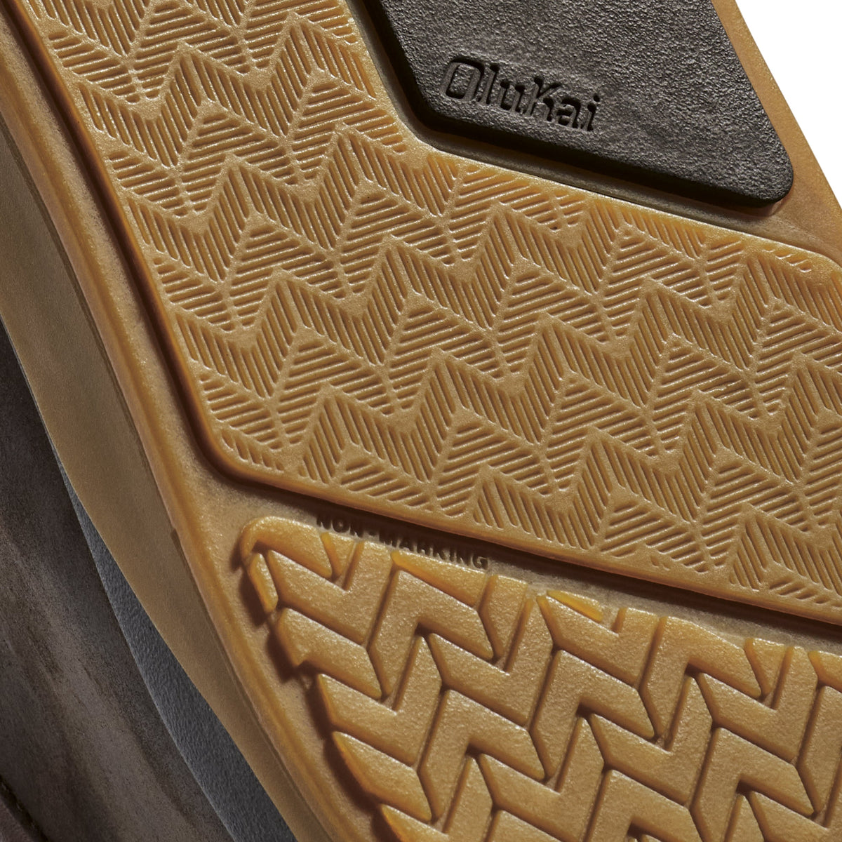 Toffee-colored car floor mat with geometric quilted pattern and dark rubber heel pad marked with brand name.