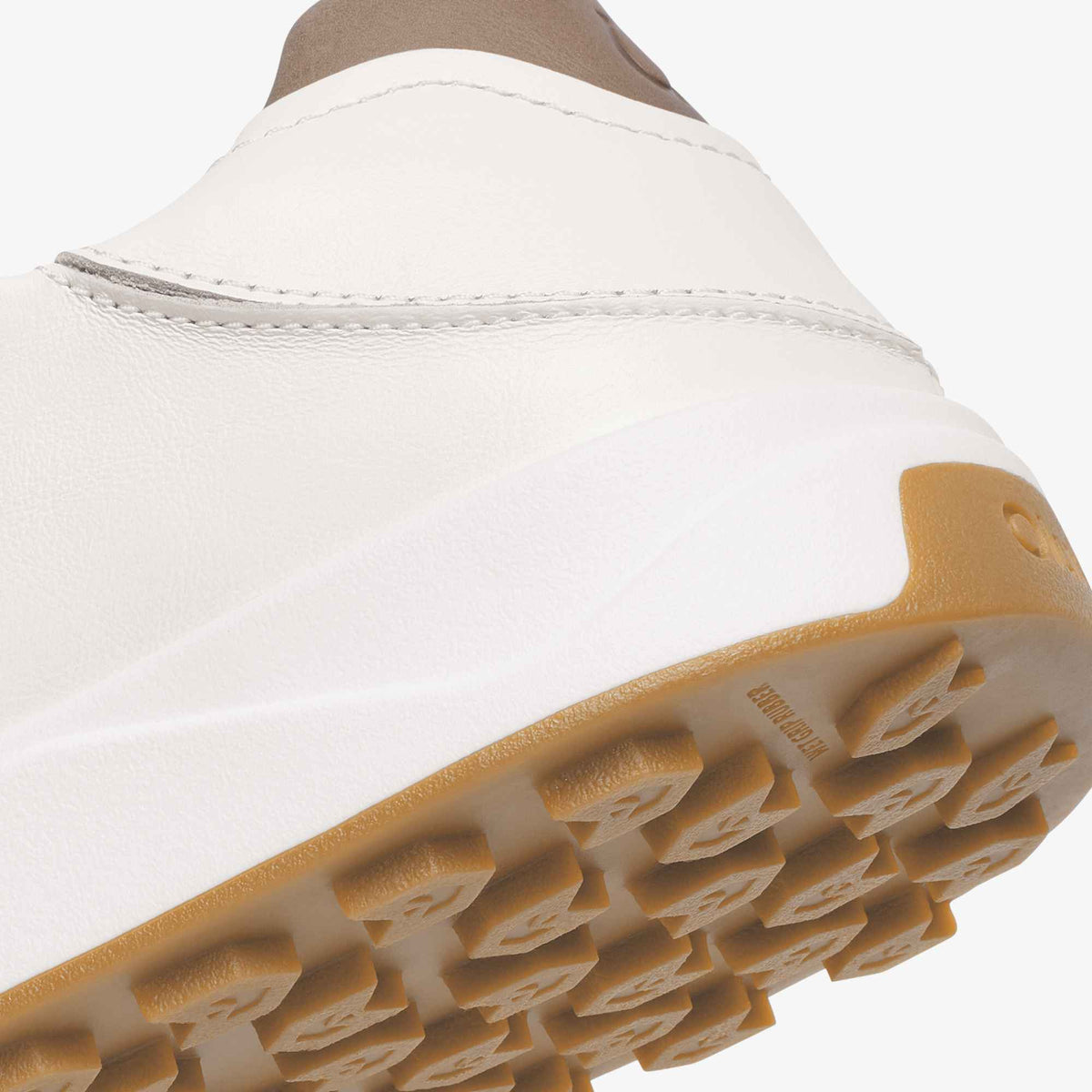 White leather shoe with tan rubber sole and heel detail, viewed from above at an angle.