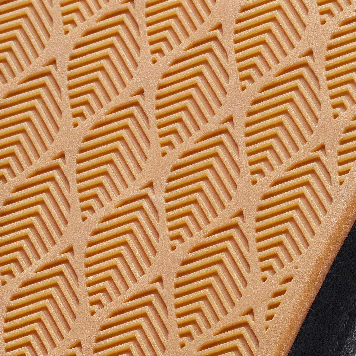 Tan leather sole with geometric chevron and rectangular cutout pattern detail.