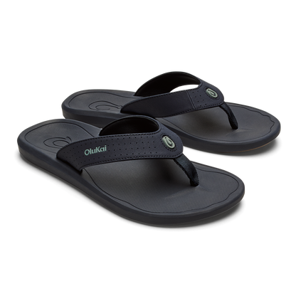 Pair of dark blue OluKai Ki'i flip-flops with textured footbeds and fabric thong straps.