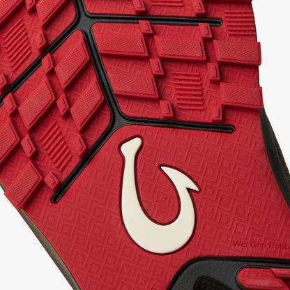Red rubber sole with textured tread pattern, black trim, and white curved hook logo detail.