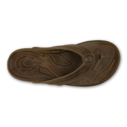 Tan leather flip-flop sandal with decorative carved patterns on the sole and straps.