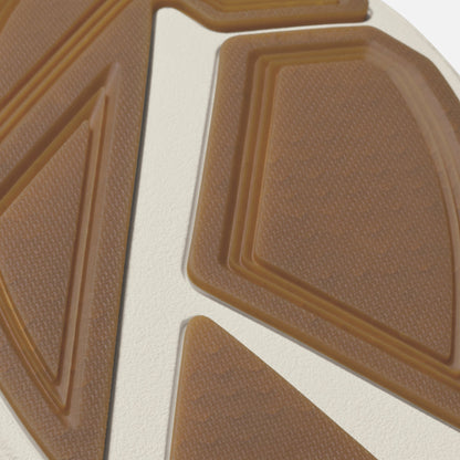 Clay and mustard colored shoe sole with textured tread pattern and white stripe detail.