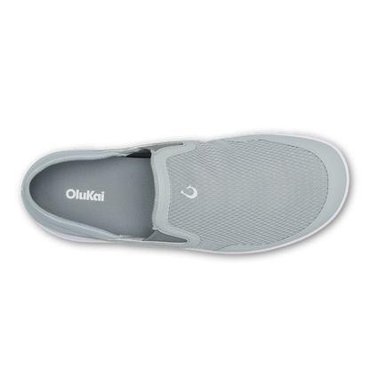 Grey slip-on shoe with textured upper, white sole, and OluKai branding on insole, shown from above.