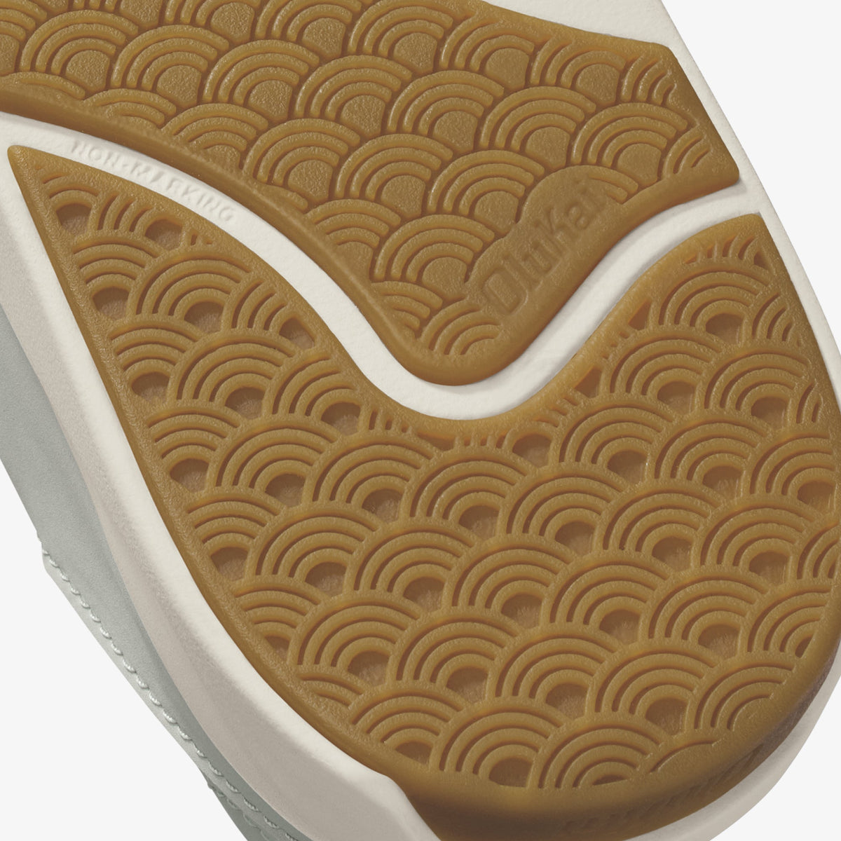 Tan and white shoe sole with geometric arc pattern detail and embossed branding.