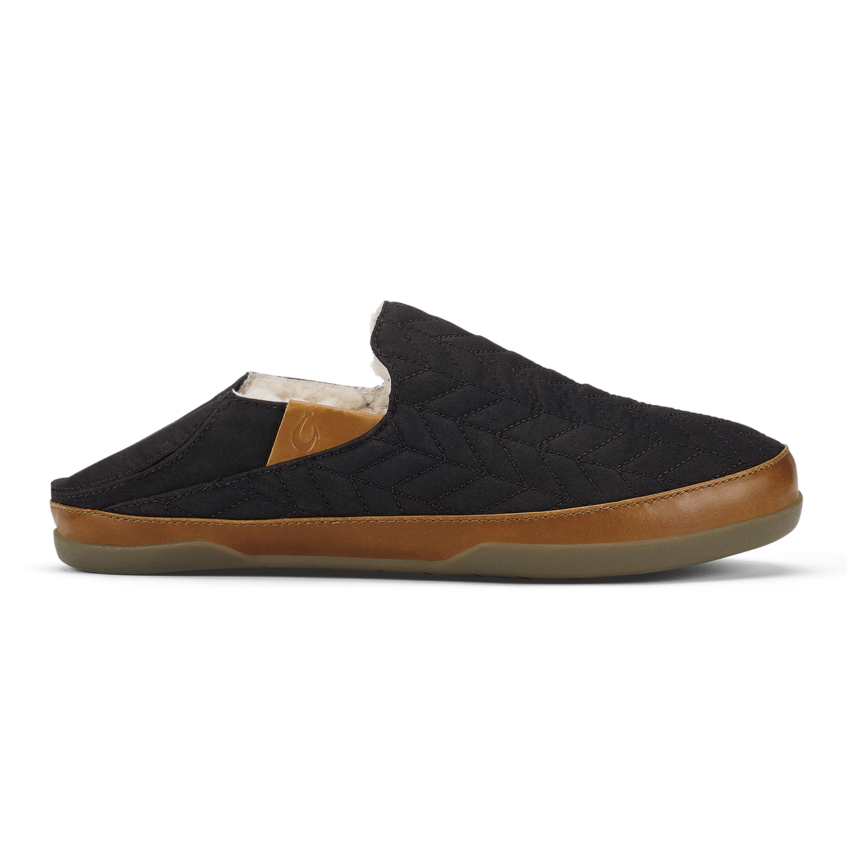 Black quilted mule slipper with tan leather trim and beige fleece lining.