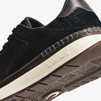 Black knit and leather sneaker with cream midsole and textured brown rubber sole, shown from side angle.