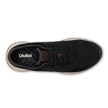 Black mesh and suede sneaker with brown leather heel tab and beige sole, shown from above.