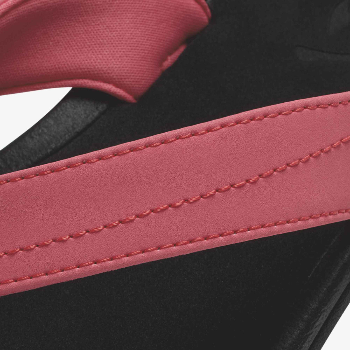 Hot pink strap with stitching detail over black textured material.