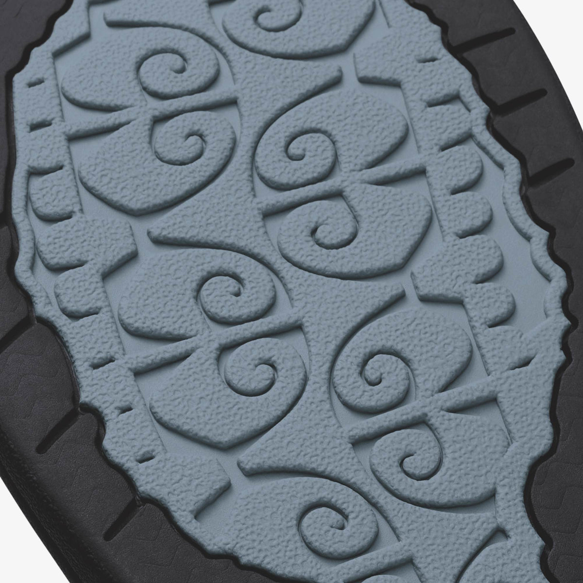 Light blue sole with embossed spiral and floral pattern design, black tread edges visible.