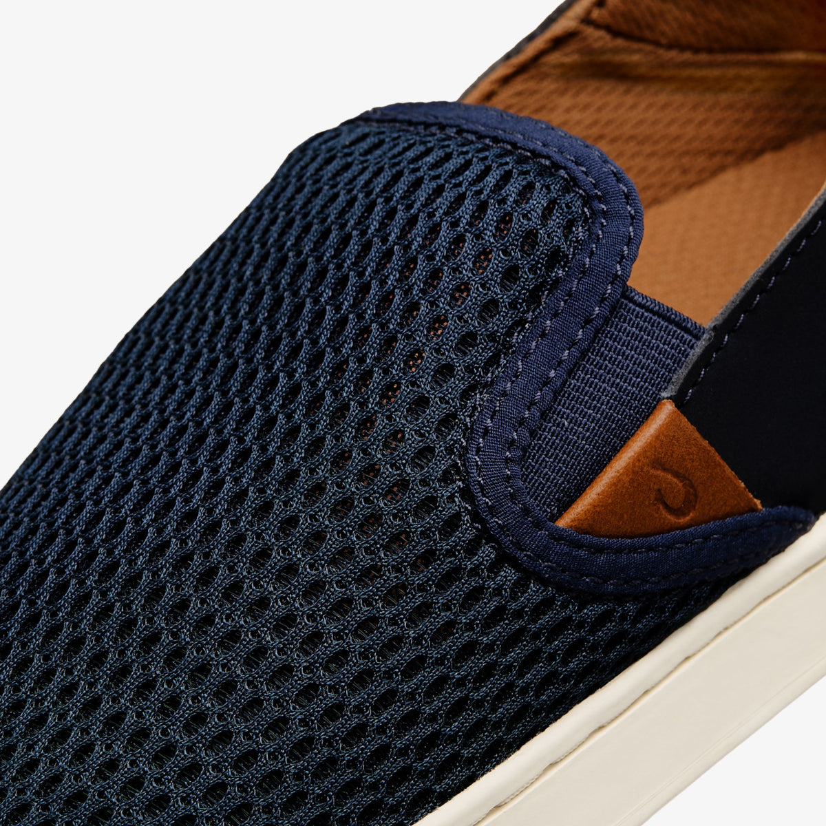 Dark blue knit slip-on shoe with tan suede heel accent and cream rubber sole.