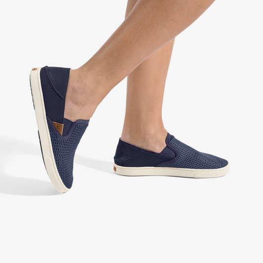 Navy blue slip-on shoes with textured fabric upper and cream-colored sole, shown on feet.