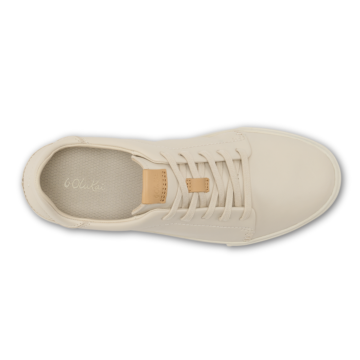 Cream canvas sneaker with tan leather heel tab and white laces, shown from above.