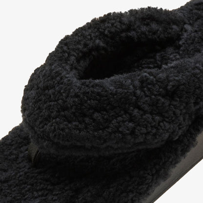 Black textured knit scarf with chunky cable knit pattern and gathered folds.
