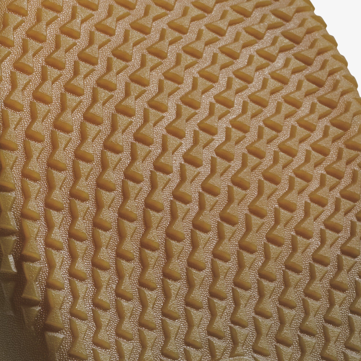 Tan textured material with geometric quilted pattern of repeating diagonal lines and rectangular indentations.