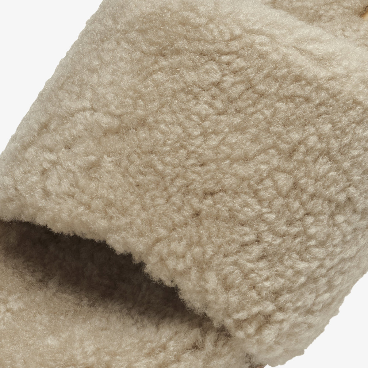 Tan wool textile with textured, chunky knit surface and folded edge detail.