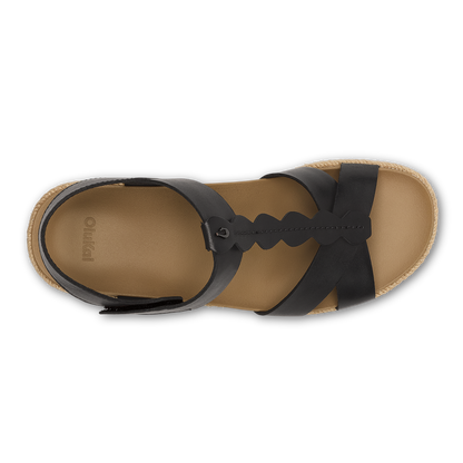 Flat lay of black leather and warm sand espadrille sandal with ankle strap and cork sole.