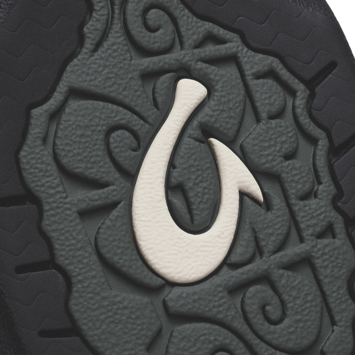 Black textured surface with white hook symbol and embossed tribal-style pattern detail.