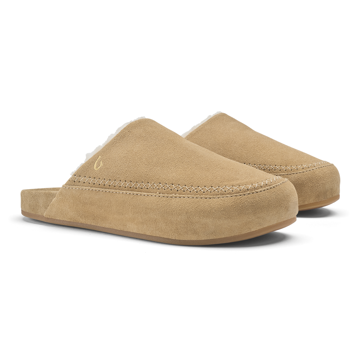 Pair of tan suede slip-on mules with stitched seams and rounded toe design.