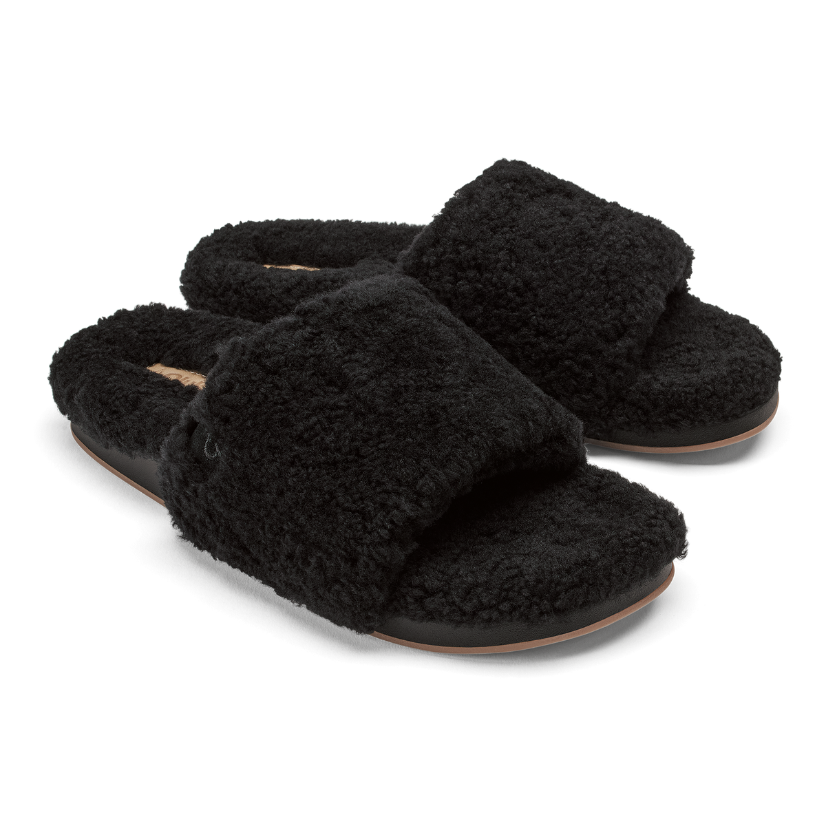 Pair of black fuzzy slippers with tan leather soles and cushioned footbeds.